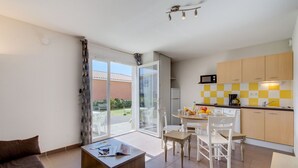 Un appartement moderne doté d’un coin repas, d’une cuisine et d’un balcon avec vue.