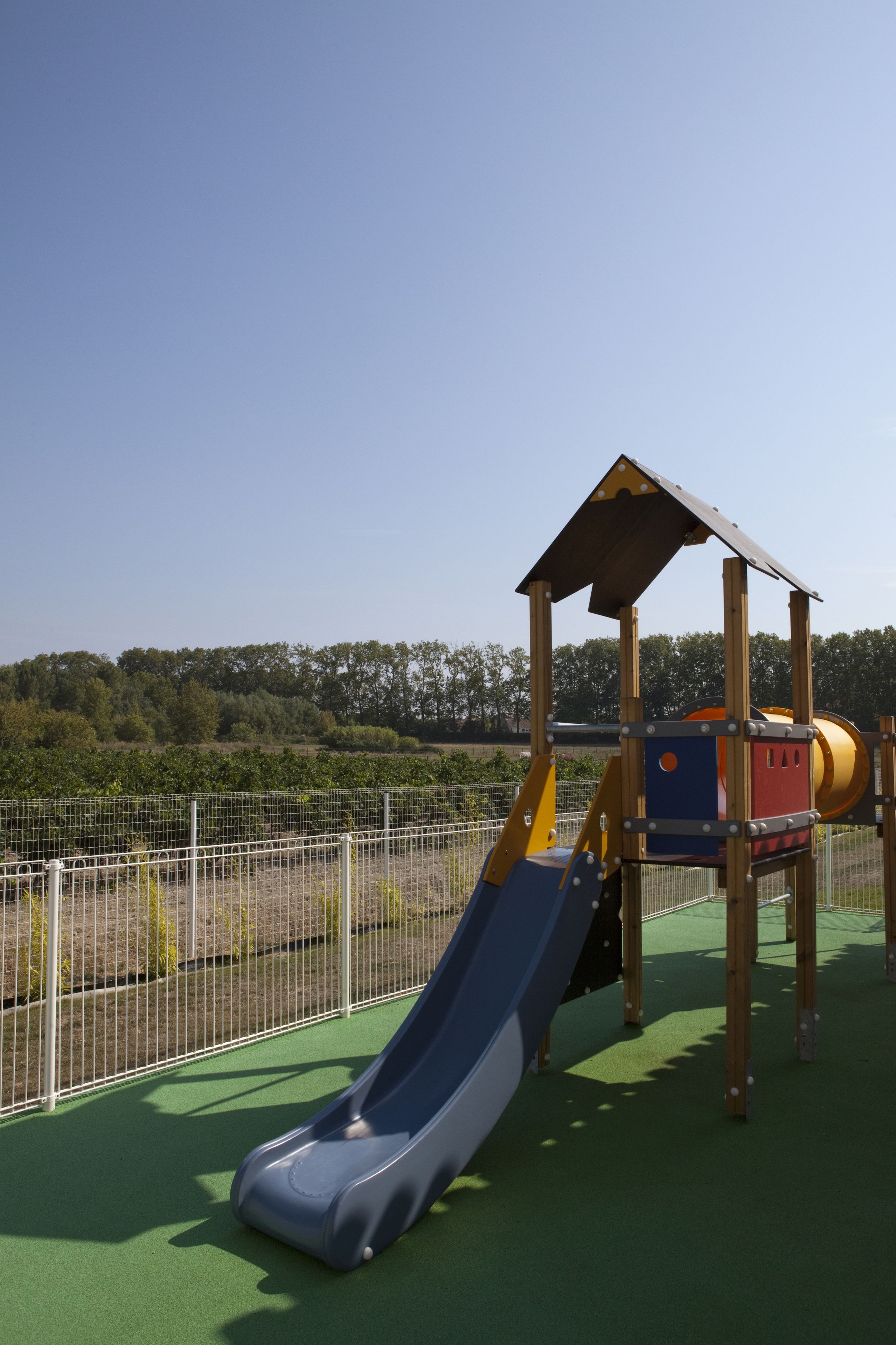 Un parque infantil con un tobogán y una estructura para escalar.