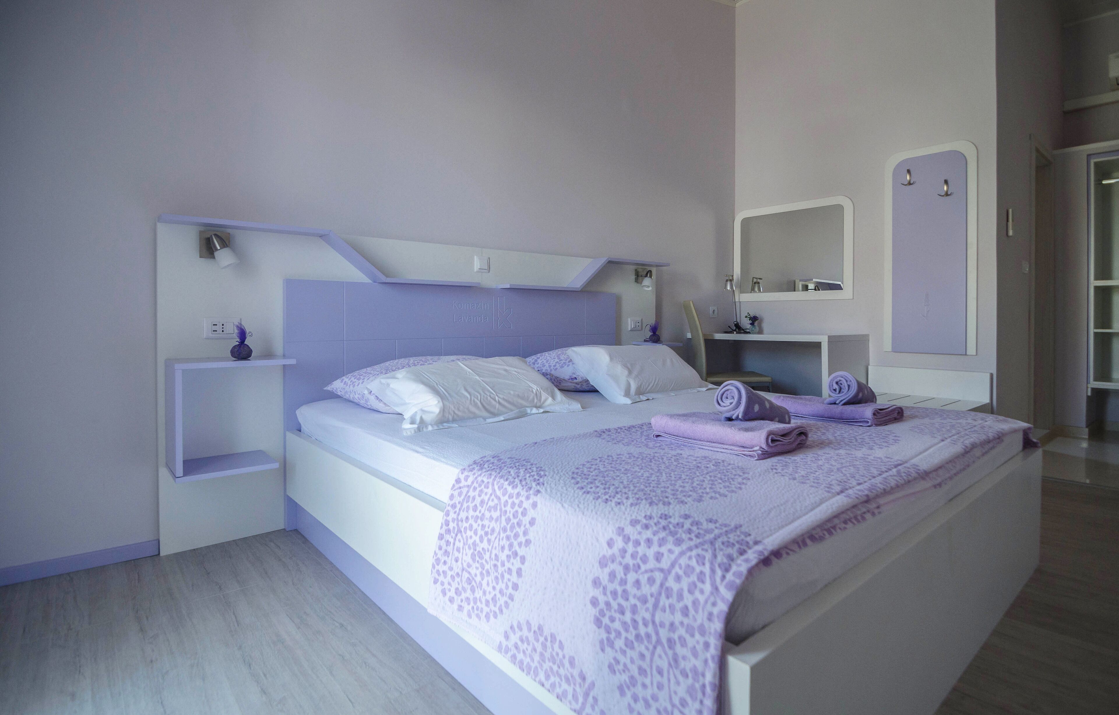 Un dormitorio con cama, mesita de noche, cómoda y espejo.