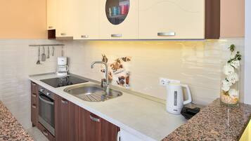Een moderne keuken met een granieten aanrecht, een roestvrijstalen spoelbak en een ingebouwde oven.