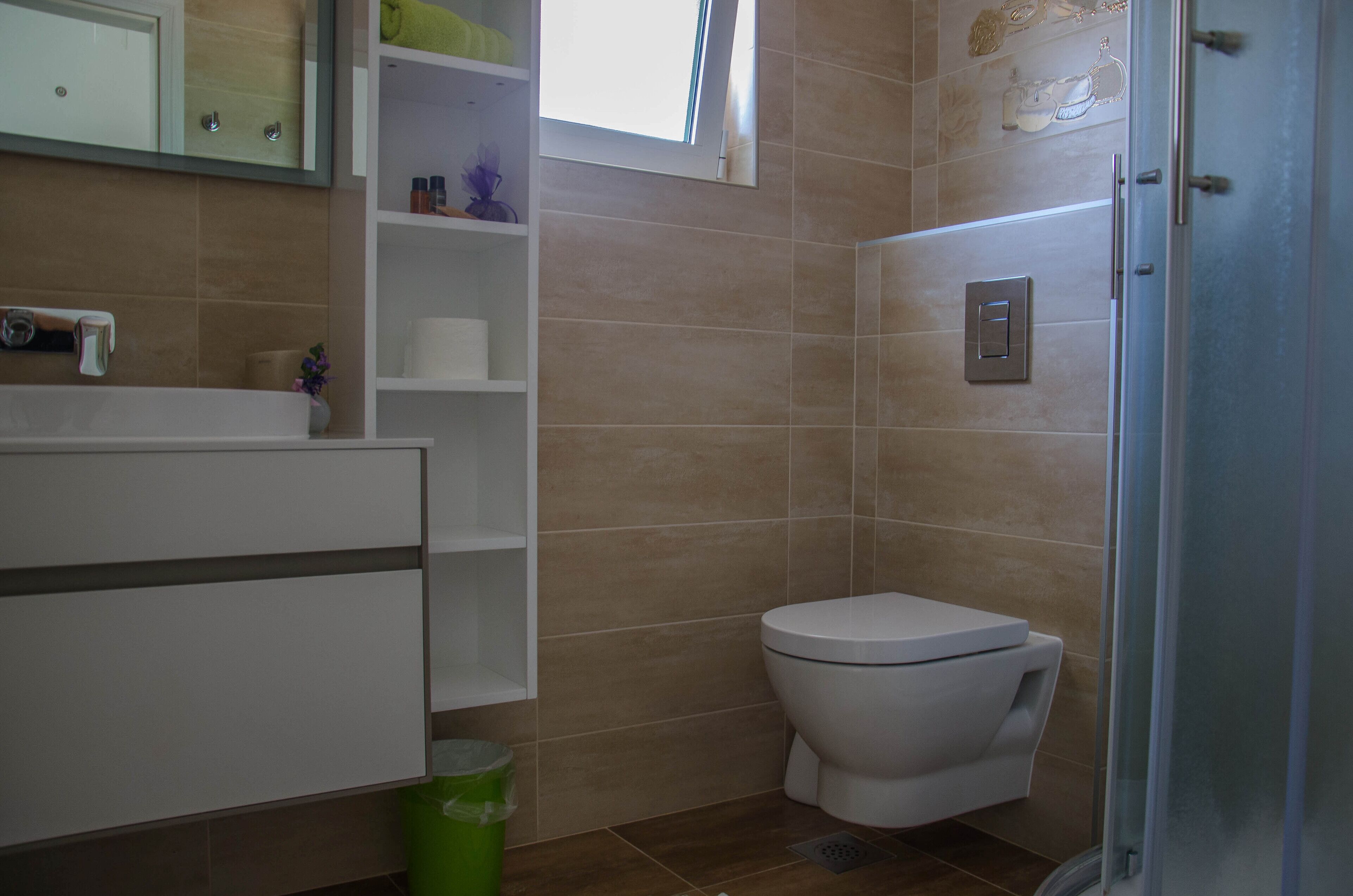 A bathroom with a toilet, a sink, and a shower area.