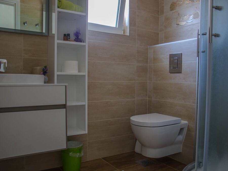 A bathroom with a toilet, a sink, and a shower area.