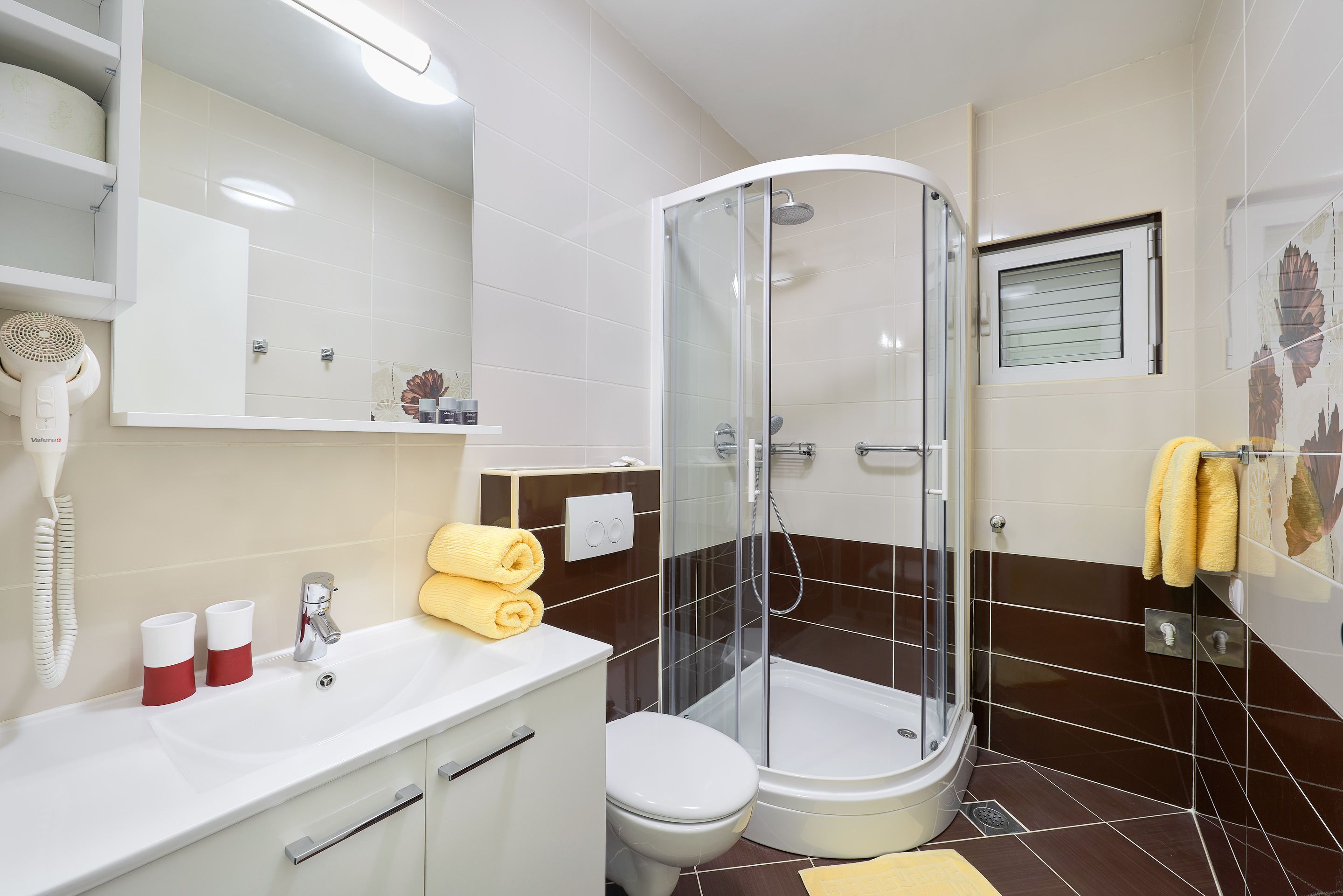 Een moderne badkamer met douche, toilet en wastafel.