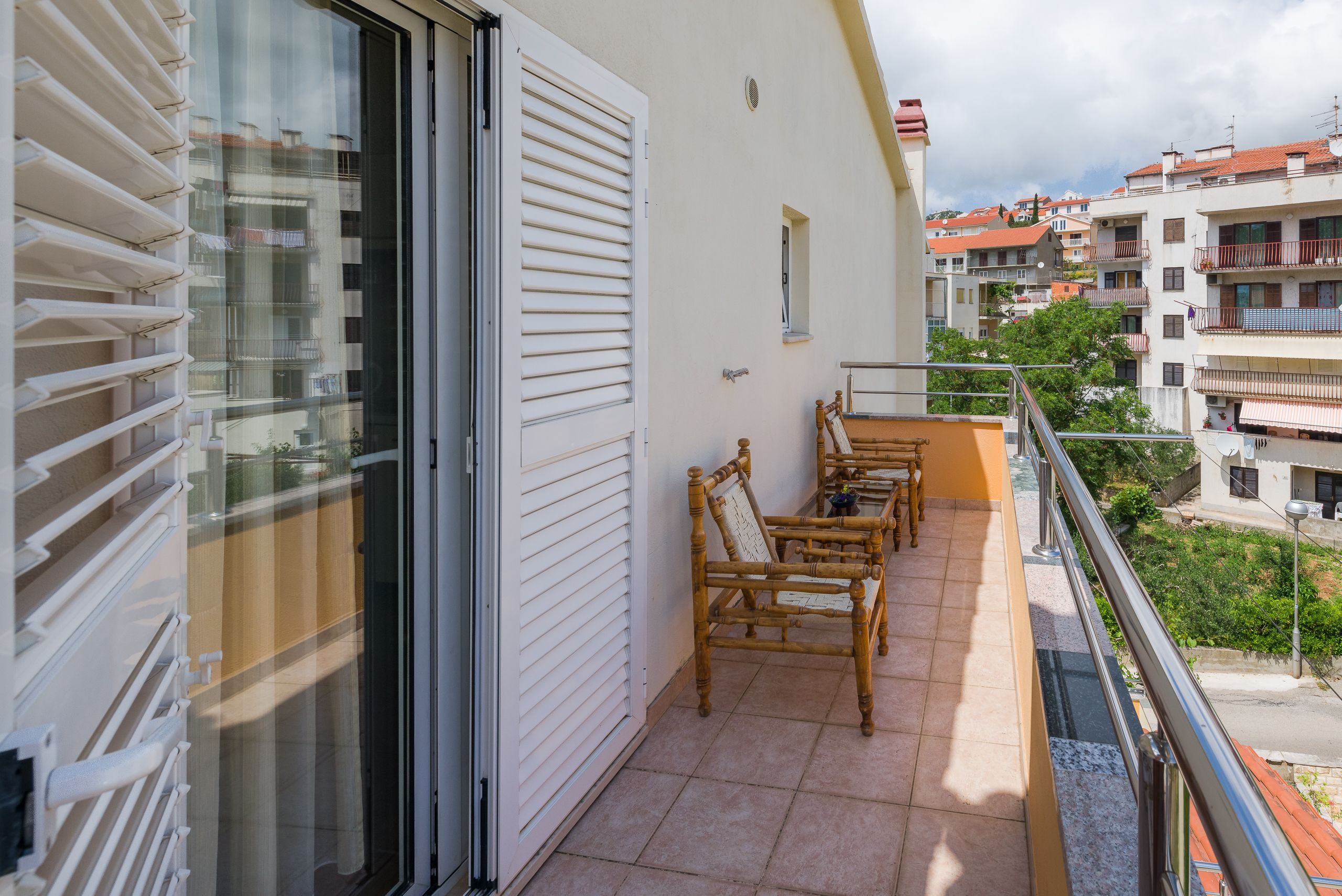 A balcony with a sliding door, a small table, and two chairs.