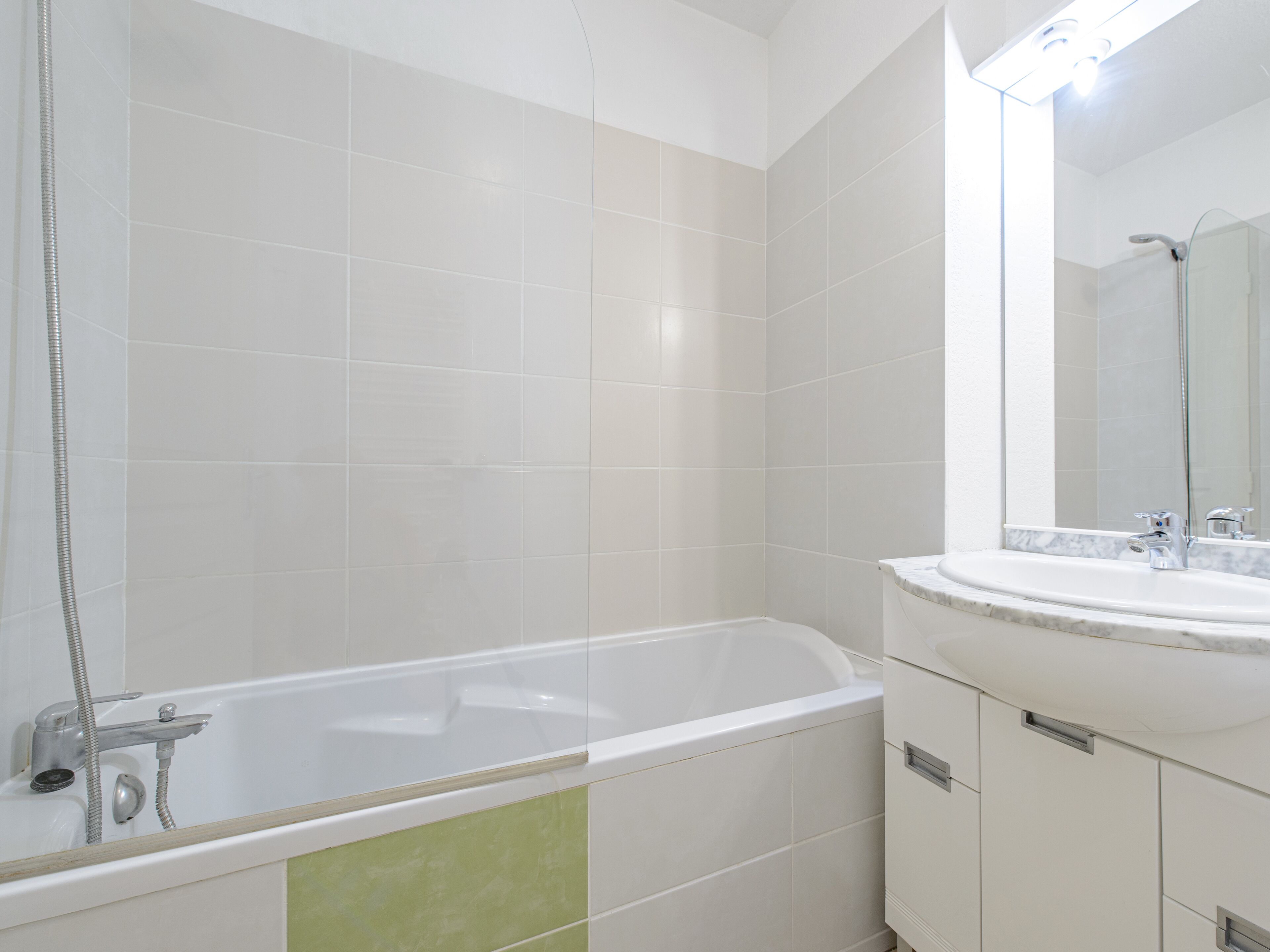 A modern bathroom with a bathtub, a shower, and a sink.