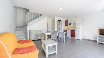 A modern apartment with a staircase, a dining area, and a kitchen.