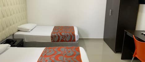 Una habitación de hotel con dos camas, un escritorio y un armario.
