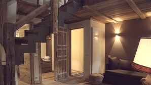 Un interior de madera con una escalera, un sofá y una lámpara.
