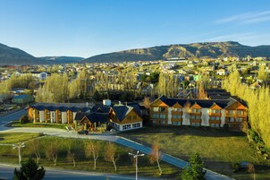 Zona residencial con una hilera de edificios de varios pisos, probablemente un hotel o complejo de apartamentos, con vistas despejadas del paisaje y las montañas circundantes.