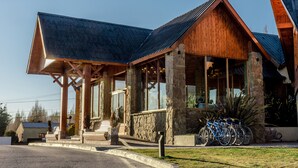 Un bâtiment doté d’une façade en pierre, de grandes fenêtres et d’un toit en bois.