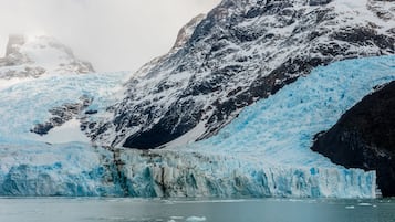 Un glaciar con una gran formación de hielo en primer plano y una montaña al fondo.