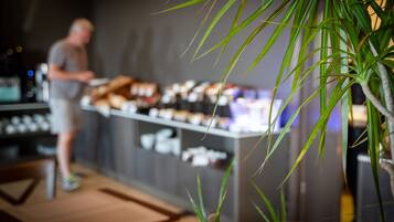Interior borroso de una cafetería con una barra que exhibe diversos productos.