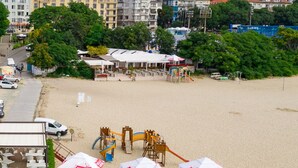 A beach with a playground, tents, and a parking area. - Hotel Panorama (Varna)