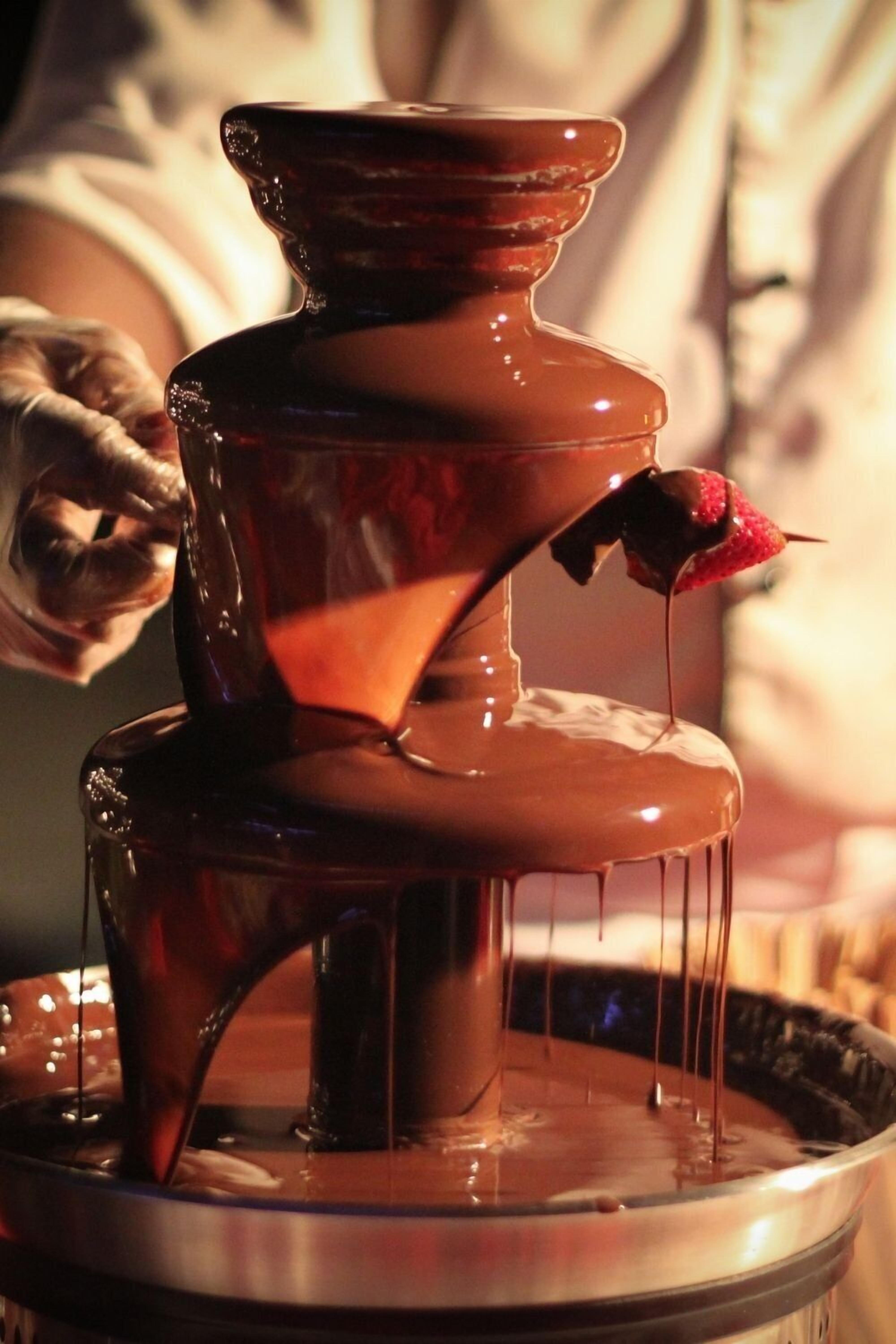 Uma fonte de chocolate com uma morango banhado em chocolate.