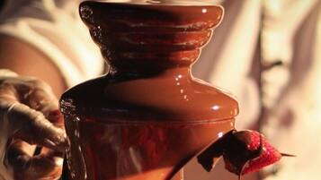 Uma fonte de chocolate com uma morango banhado em chocolate.
