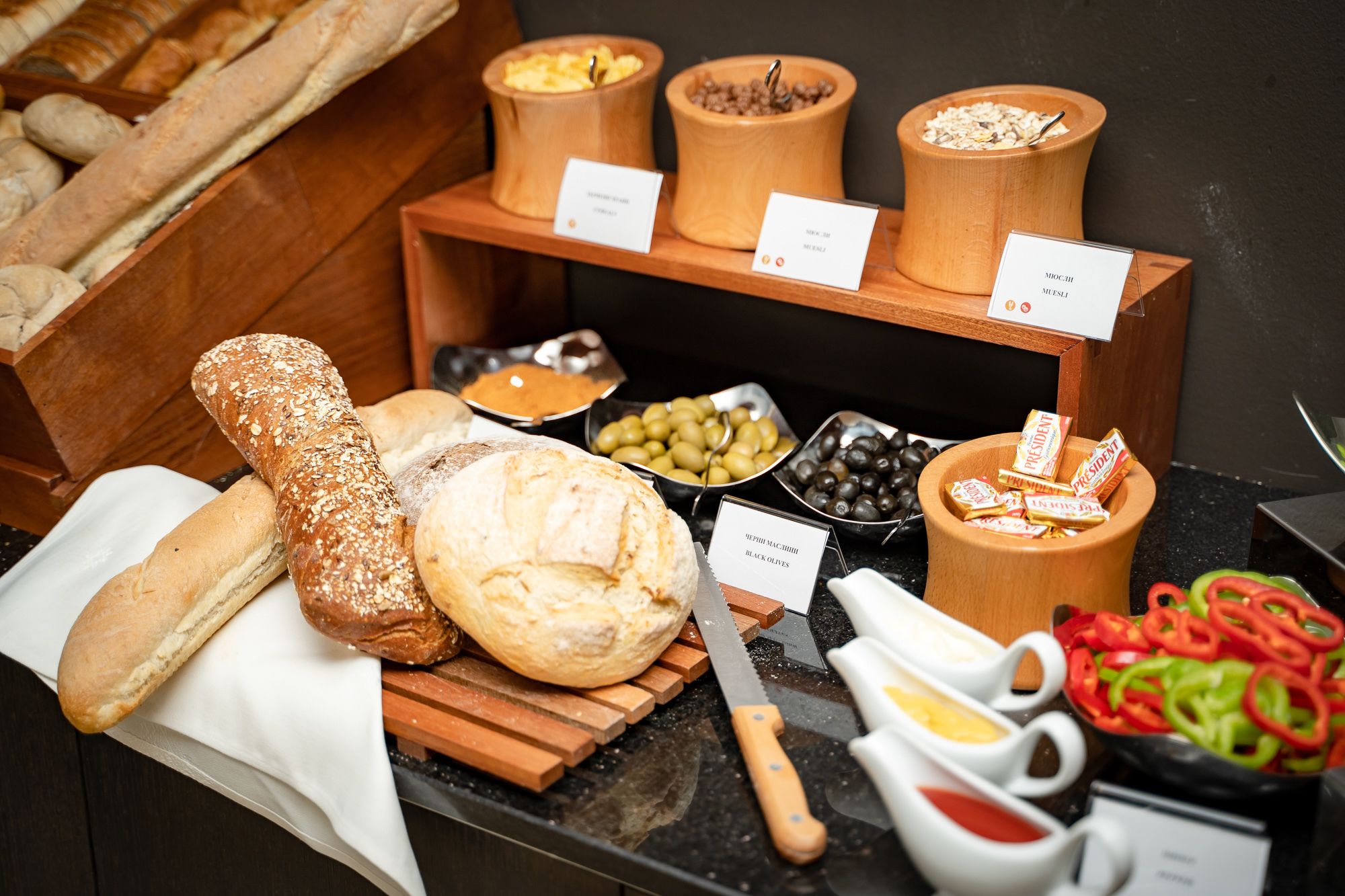 Un buffet proposant une variété de pains, d’olives, d’olives noires et de condiments.