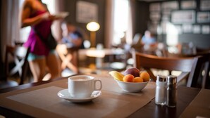 A dining table with a white cup and a bowl of fruit. - Hotel Panorama (Varna)