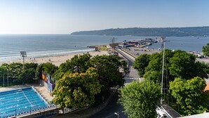A coastal area with a swimming pool, a beach, and a marina. - Hotel Panorama (Varna)