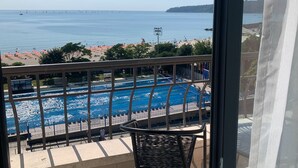 A view of a swimming pool with a clear blue sky and a distant bridge. - Hotel Panorama (Varna)