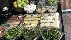 A buffet with various food items including fruits, vegetables, and dairy products.