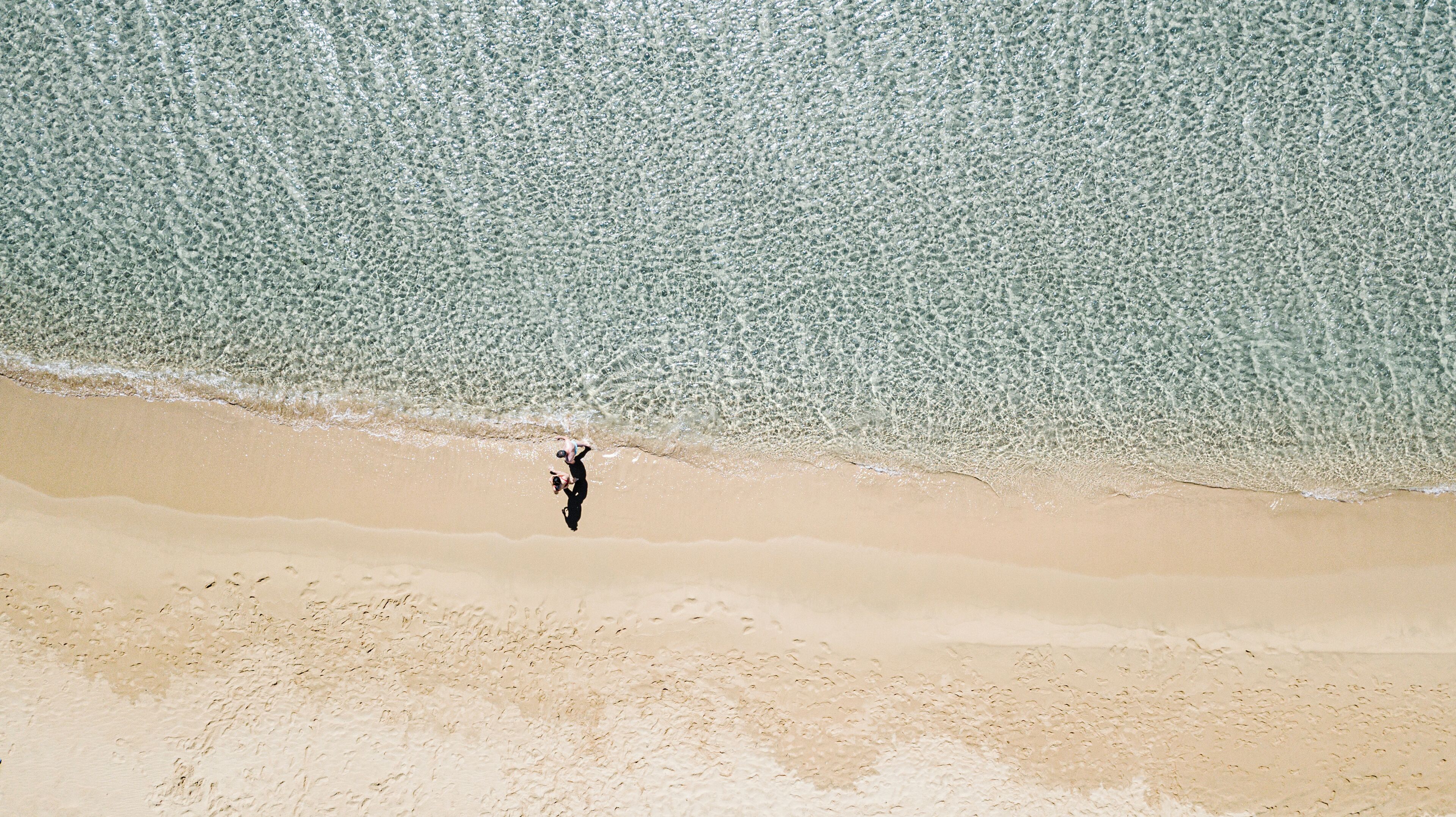 Une plage où l’on voit une personne debout dans l’eau.