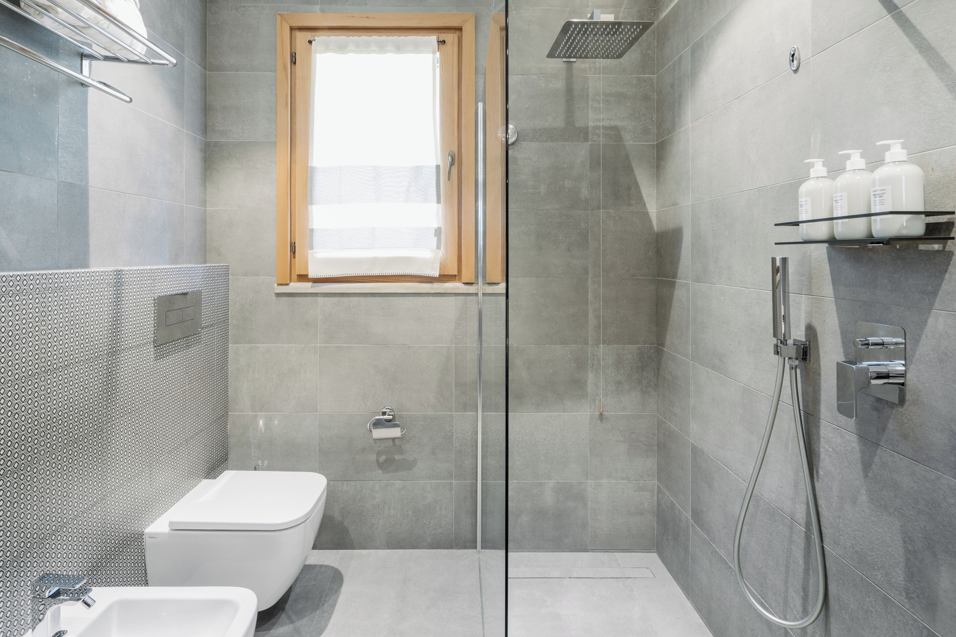 Un baño moderno con ducha, inodoro y lavamanos.
