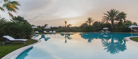 Una piscina al aire libre, tumbonas