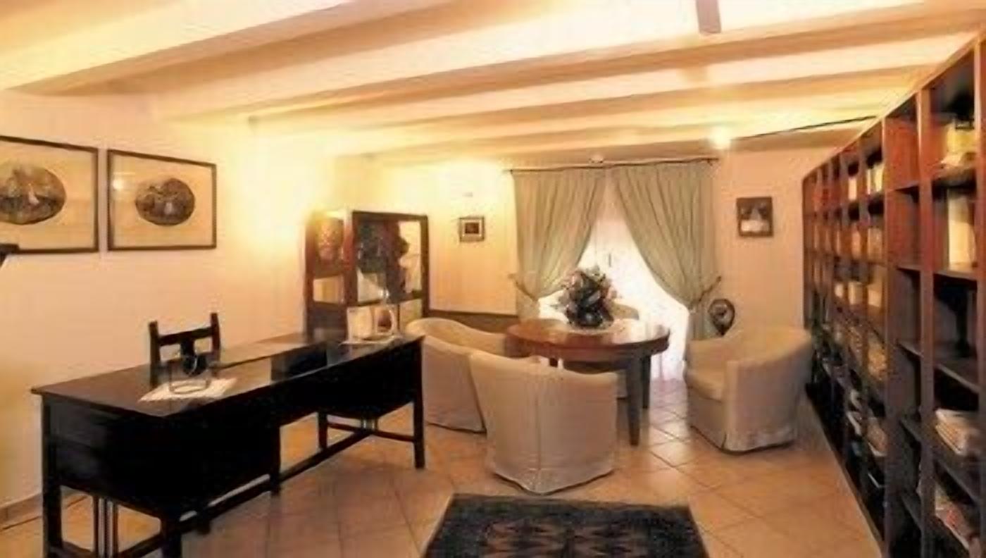 Una sala de estar con una mesa de comedor, dos sillones, un sofá y una estantería.