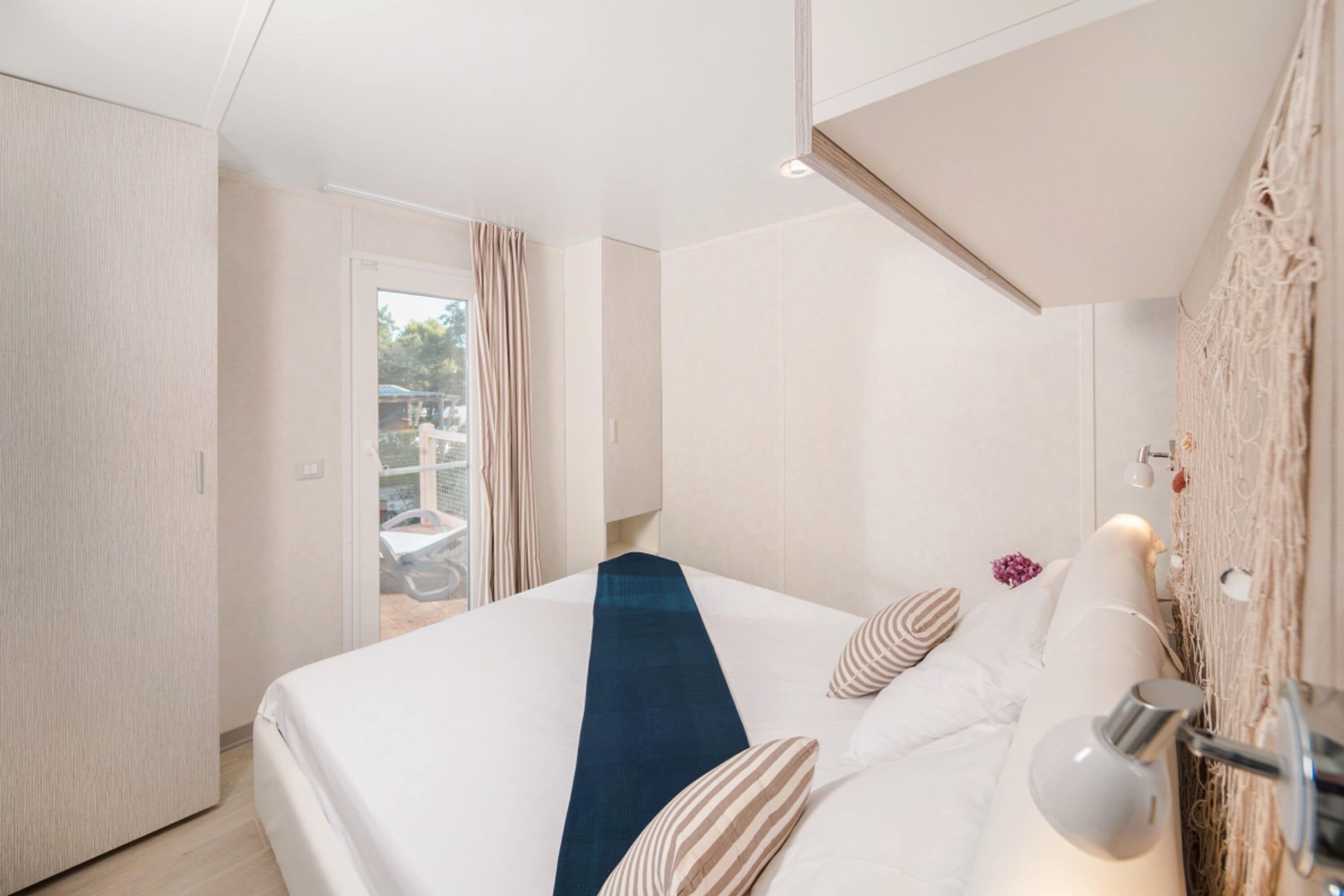 Et moderne hotelværelse med en stor seng, et skrivebord og udsigt til det fri.