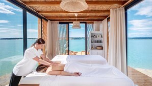 A massage room with a view of the sea, wooden furniture, and a large window. - Valamar Camping Lanterna (Tar-Vabriga)