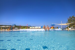 Una piscina al aire libre, una piscina climatizada, sombrillas