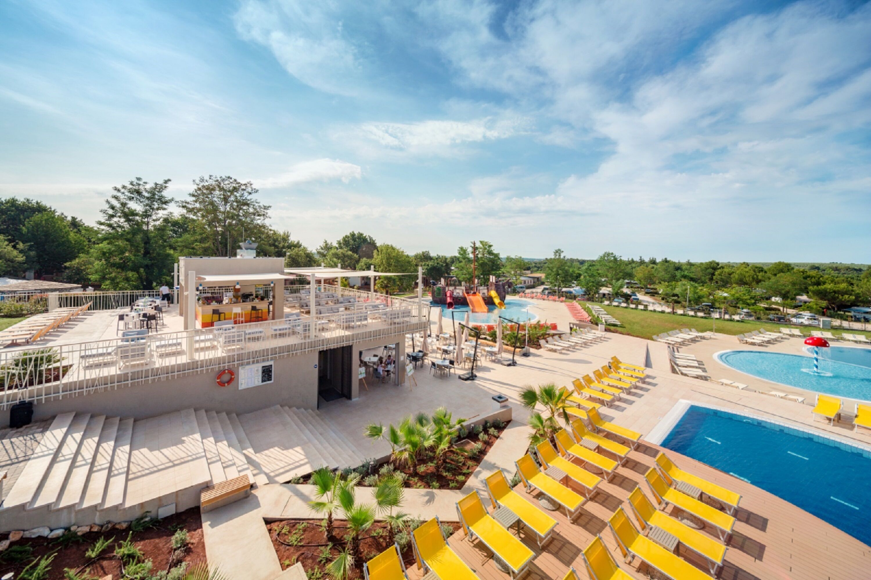 A resort with a pool area, outdoor seating, and a covered patio.