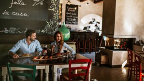A restaurant interior with a chalkboard menu, wooden tables, and chairs. - Valamar Camping Lanterna (Tar-Vabriga)