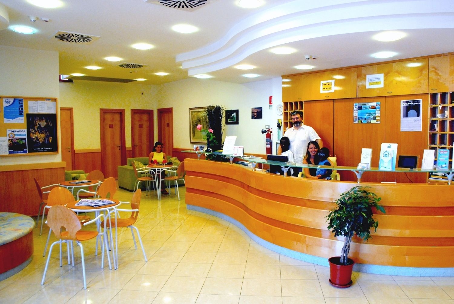 A reception area with a curved counter, several chairs, a small table, and a potted plant.