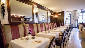 Ein Restaurant mit langen Tischen, Stühlen und dekorativen Blumen.