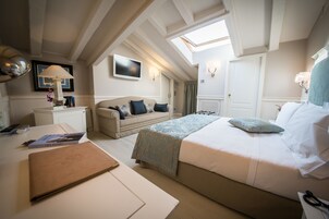 Un dormitorio con una cama, un escritorio, una lámpara y un tragaluz.