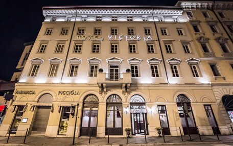 A hotel facade with the name "HOTEL VICTORIA" and "PICCIOLAI" at the ground level.