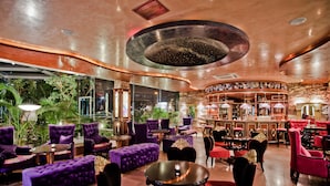 A spacious lounge area with plush seating, a central bar, and a view of the outdoors. - Hotel Maritza (Plovdiv)