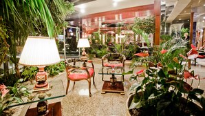 A well-lit indoor space with furniture, plants, and decorative items. - Hotel Maritza (Plovdiv)