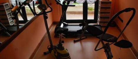 Una palestra con attrezzature per esercizi, tra cui tapis roulant, cyclette ed ellittica.
