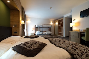 A hotel room with two beds, a desk, a chair, and a TV. - Vedig (Valfurva)