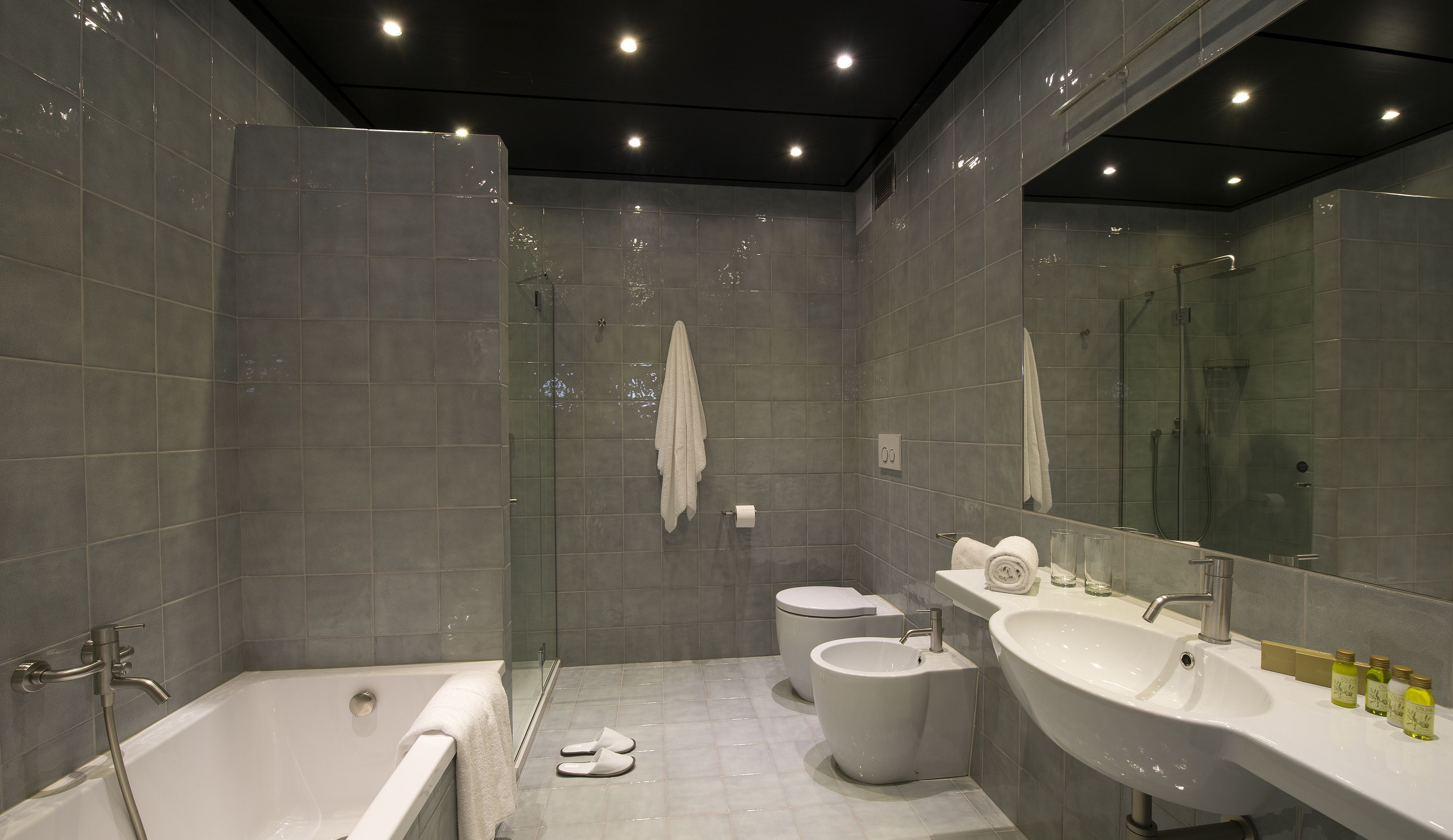 A modern bathroom with a bathtub, toilet, and sink.