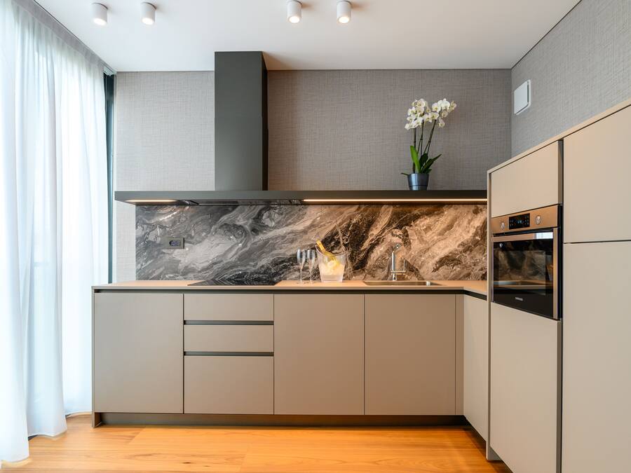 A modern kitchen with a marble backsplash, stainless steel appliances, and a minimalist design.