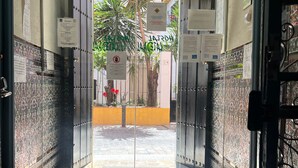 A hotel entrance with a glass door, tiled walls, and a stone floor. - Pensión Catedral (Seville)