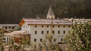 Un bâtiment doté d’une tour, entouré d’arbres et d’autres constructions.