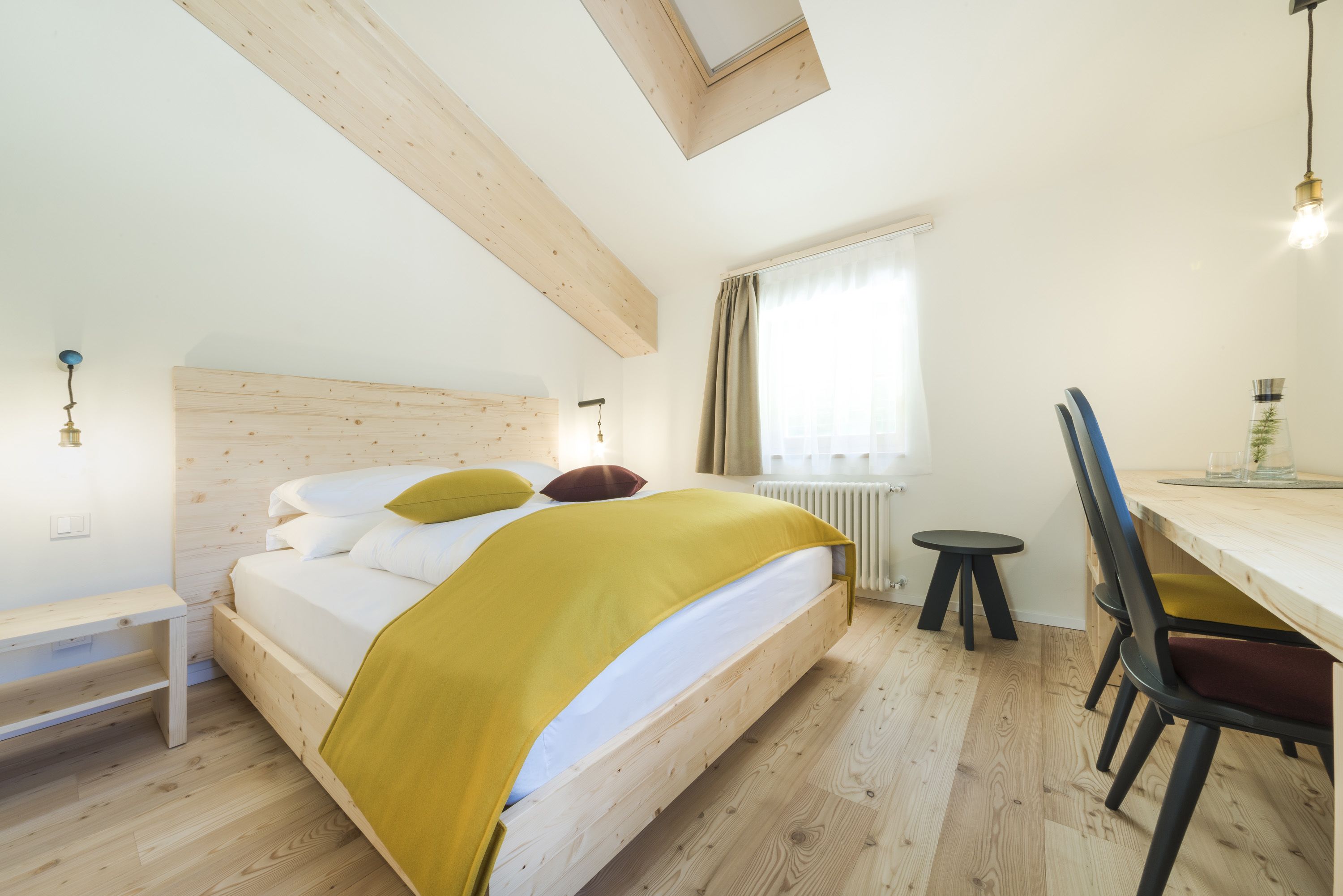 Un dormitorio con una cama de madera, un escritorio y una silla.