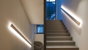 Un escalier avec des rampes en bois et un mur de pierre en bas.