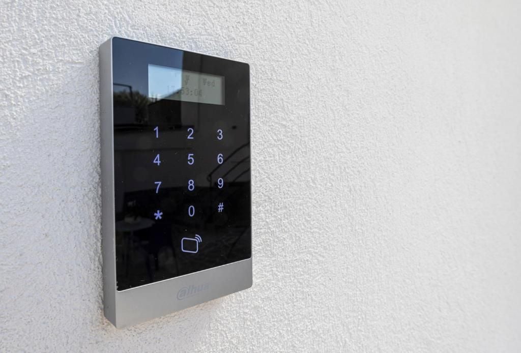 Eine wandmontierte Tastatur mit digitaler Anzeige, Tasten mit den Ziffern 0 bis 9, sowie Sternchen und Nummernzeichen.