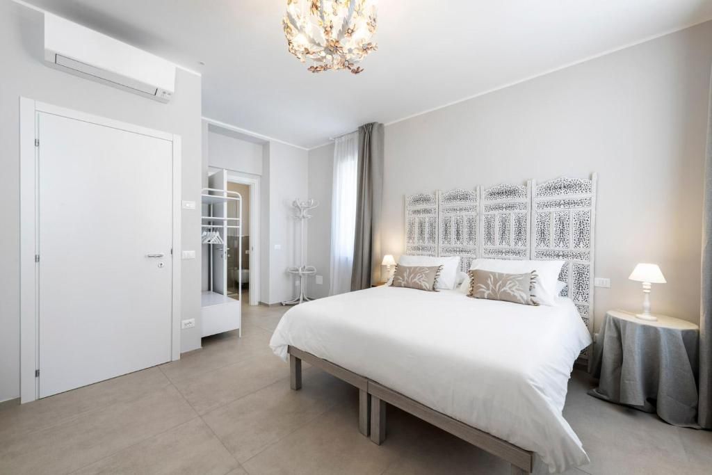 A modern bedroom with a large bed, bedside tables, a wardrobe, and a decorative wall panel.