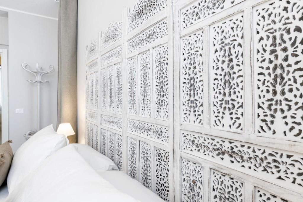 Une chambre d’hôtel comprenant un lit, une table de chevet, une lampe et un panneau décoratif mural.